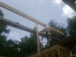 Carpenter setting a ridge beam over a new addition frame — Ice Dam Removal by Roofing Brothers in Biddeford